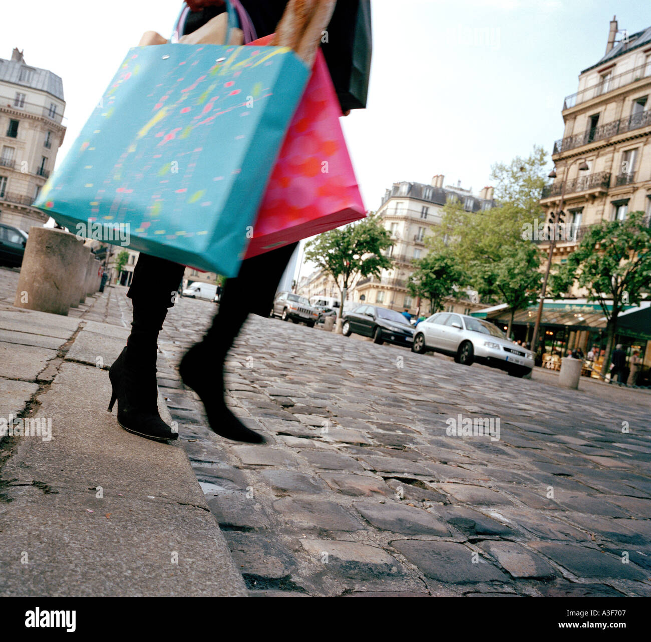 Femme en descendant de bordure avec des sacs de shopping dans la rue de Paris Banque D'Images