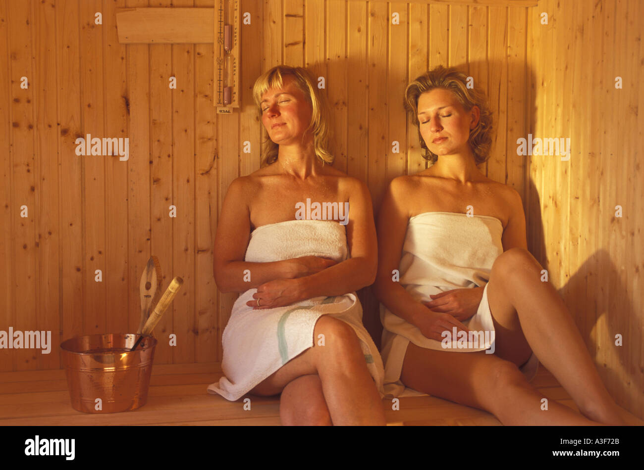 Deux femmes assises à l'intérieur d'un sauna traditionnel en bois en Suède Banque D'Images