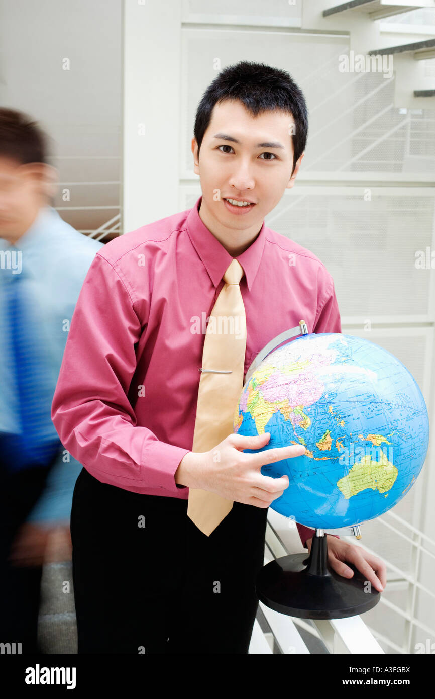Portrait of a businessman holding a globe Banque D'Images