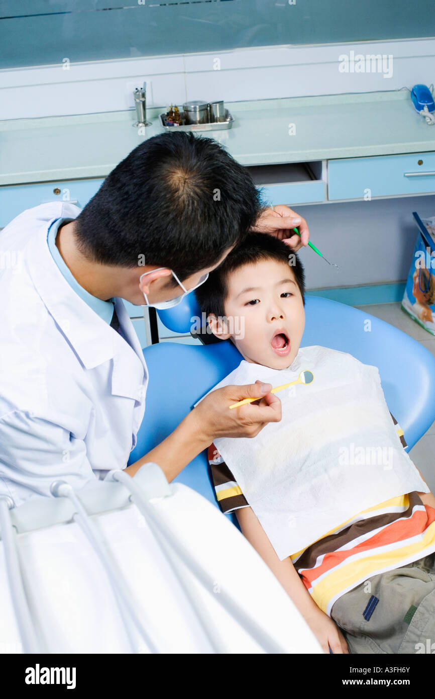 Close-up of a male dentist examining a dents du garçon Banque D'Images