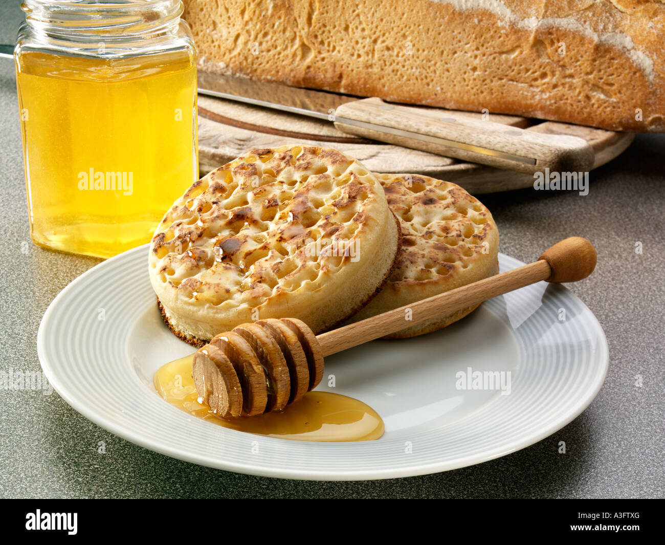 Une plaque de crumpets avec balancier au miel Banque D'Images