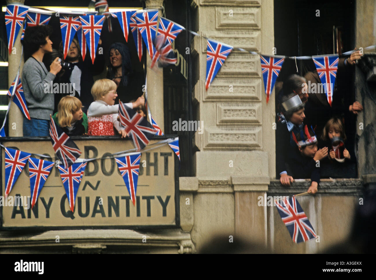 Les jeunes spectateurs agitaient des drapeaux de balcons à Londres pour célébrer le jubilé d'argent de la Reine en 1977 Banque D'Images