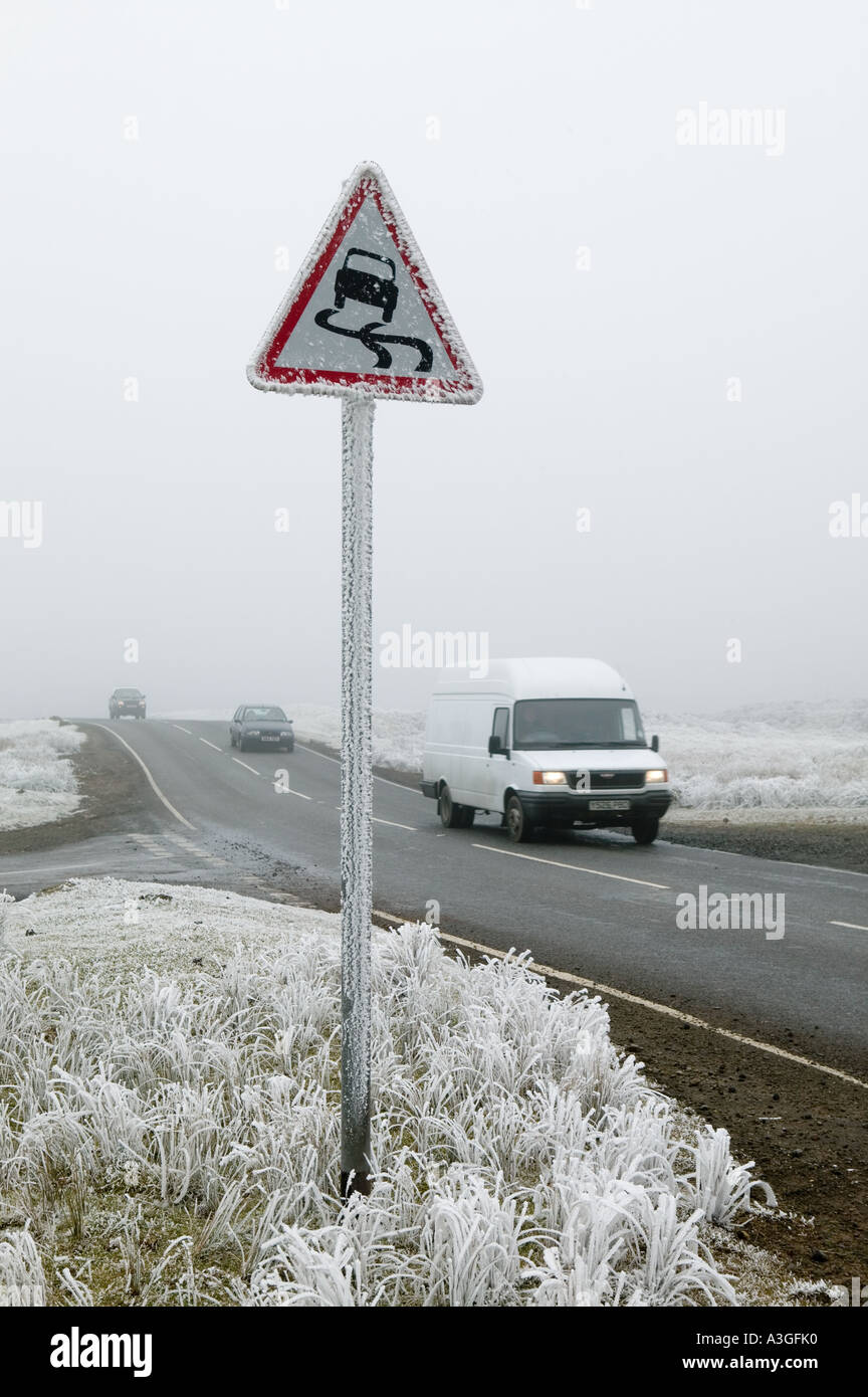 La circulation en hiver avec de la glace et neige avec panneau d'avertissement pour route glissante Samatan Pays de Galles UK Banque D'Images La circulation en hiver avec de la glace et neige avec panneau d'avertissement pour route glissante Samatan Pays de Galles UK Banque D'Images
