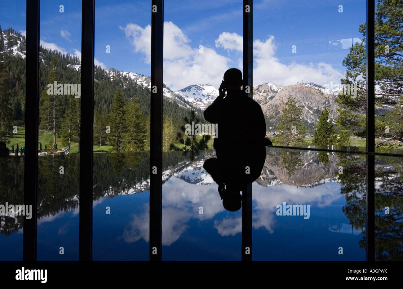 L'utilisateur du téléphone mobile avec vue sur le paysage de montagne de l'hôtel Banque D'Images