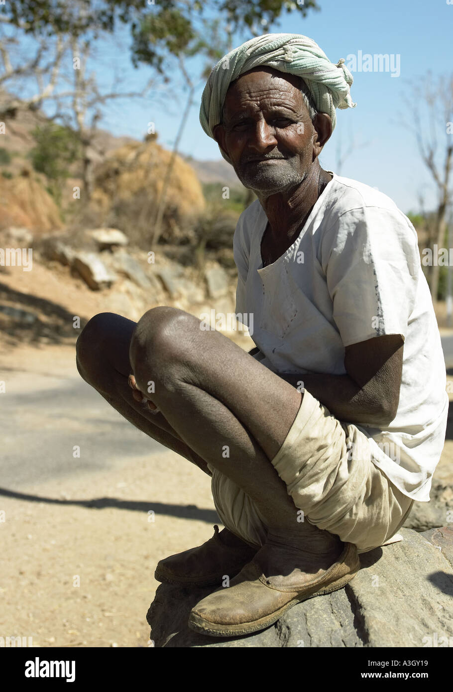 L'homme indien typique en position accroupie dans un village du Rajasthan, Inde Banque D'Images