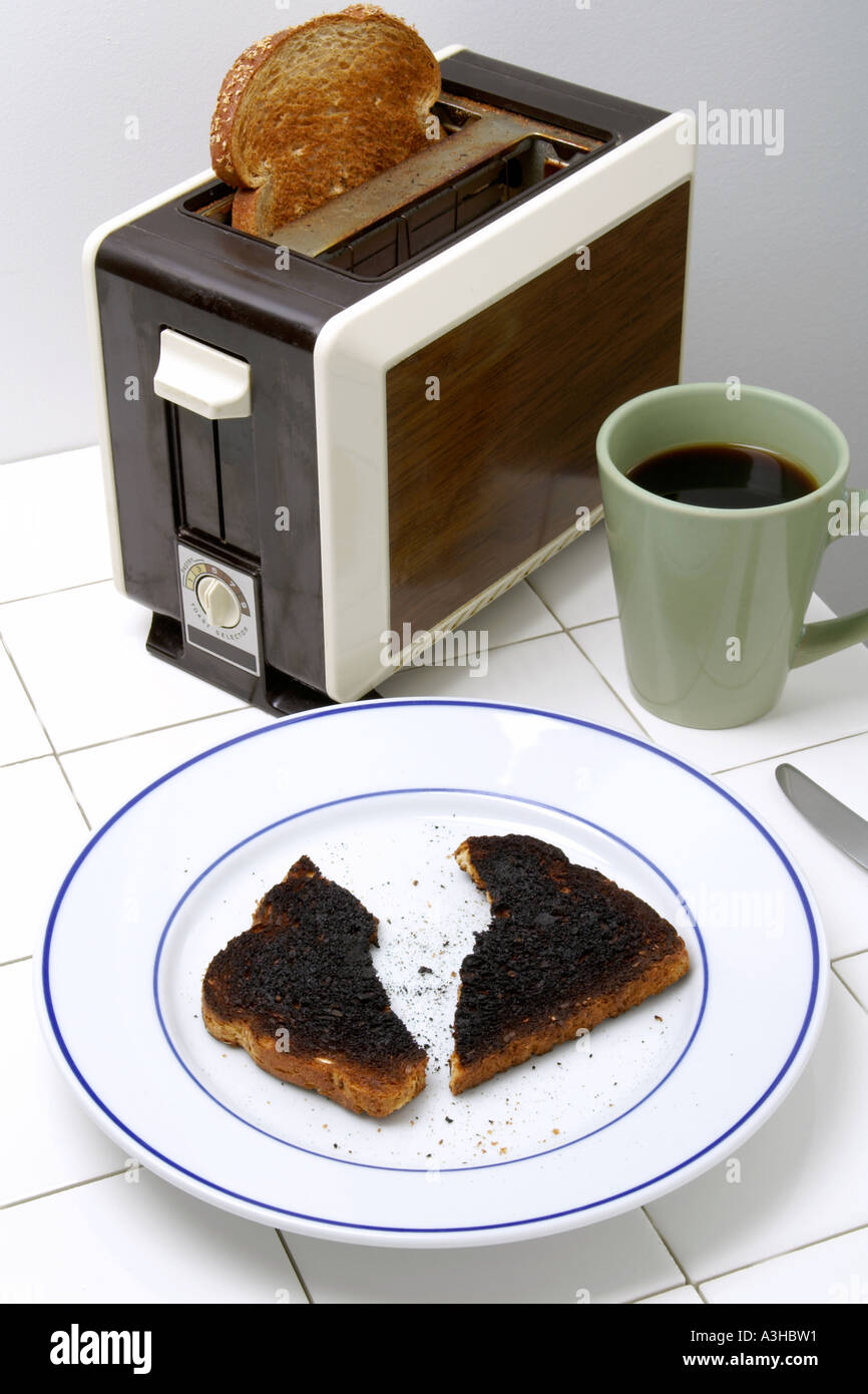 Rompu le pain brûlé sur la plaque avec grille-pain et bouilloire Banque D'Images