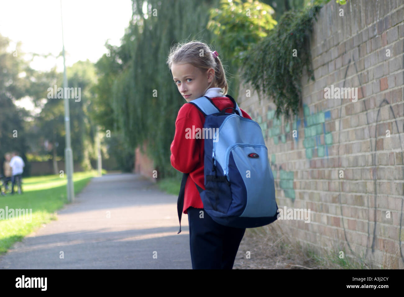 Fille sur son chemin du retour de l'école en passant devant quelques graffitis Banque D'Images