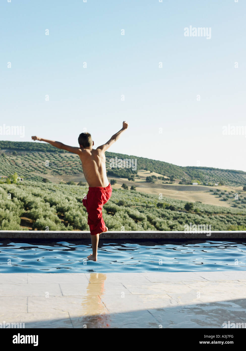 Boy jumping into swimming pool Banque D'Images