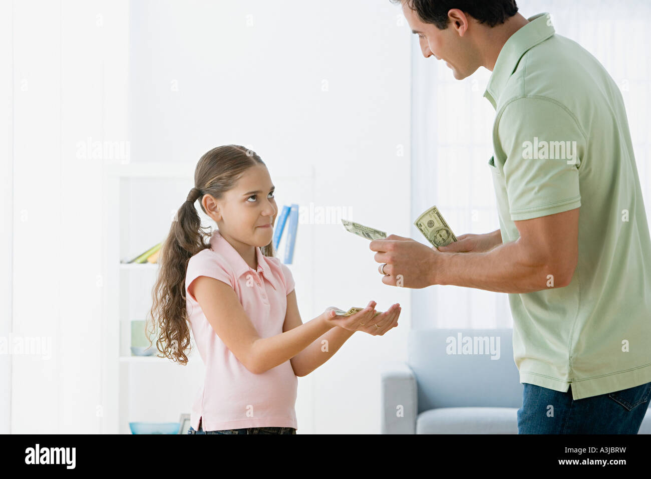 Père fille donnant de l'argent de poche Banque D'Images