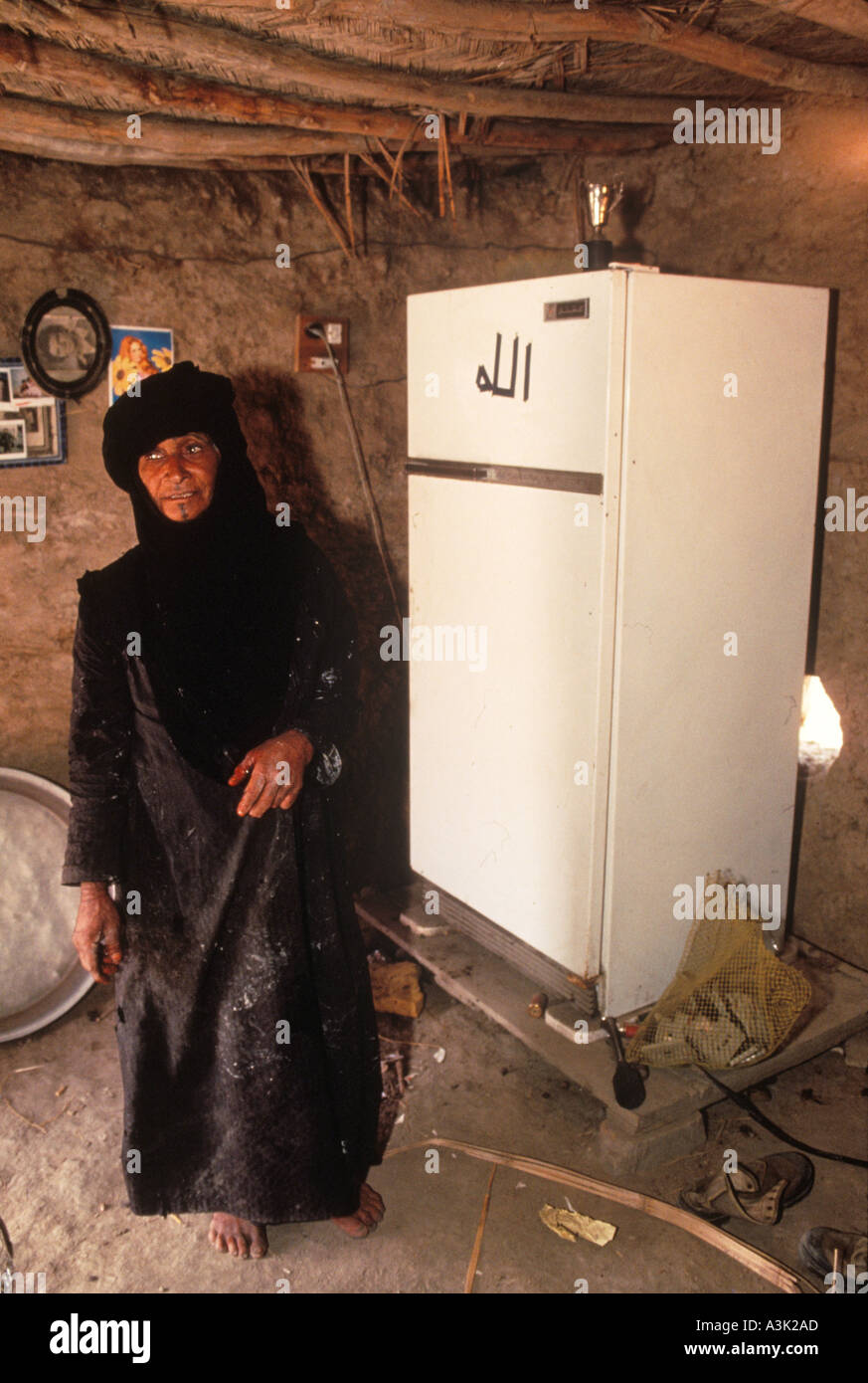 Marsh Arabs Iraq 1984 femme montre son nouveau réfrigérateur dans sa maison d'une pièce en adobe. Sol et murs de boue. Sud de l'Irak près de Bassorah. HOMER SYKES des années 1980 Banque D'Images