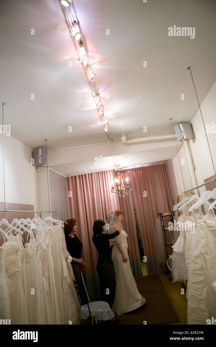 Une jeune femme se regarde dans un miroir car elle essaie sur une robe de mariée blanche dans un magasin à New York, janvier 2006 Banque D'Images