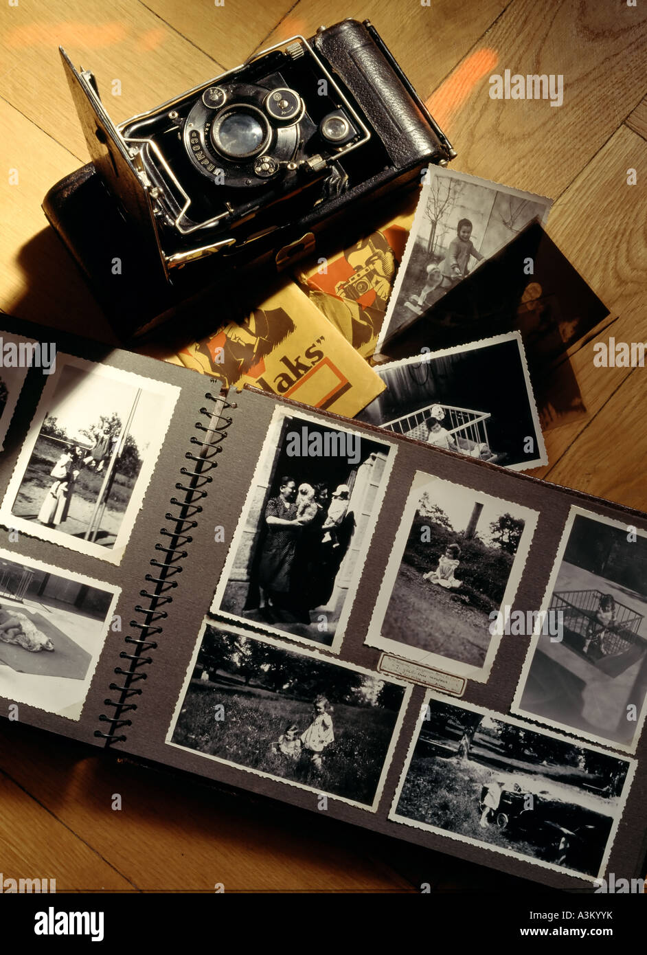 Album photo ancienne avec 1942 photos de bébé et l'appareil photo pliant ancien Banque D'Images