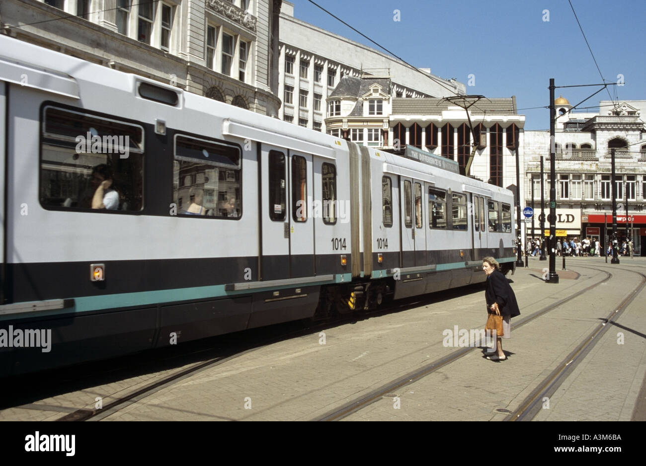 Manchester Piccadilly dame essaie de traverser la route et d'être bloqué et éclipsé par le tram Banque D'Images