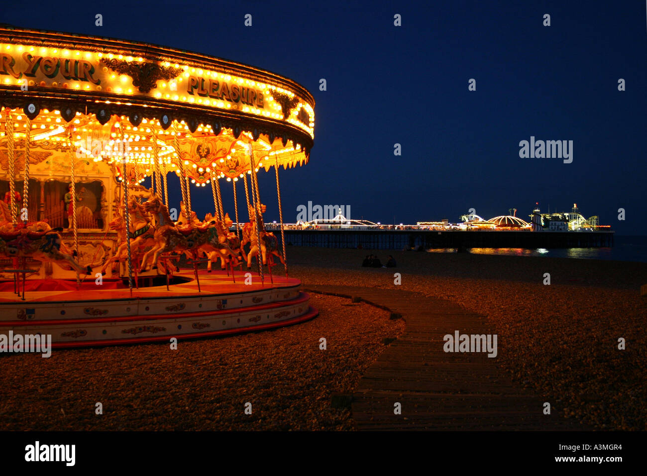 Merry-go-round et la jetée de Brighton, soir Banque D'Images