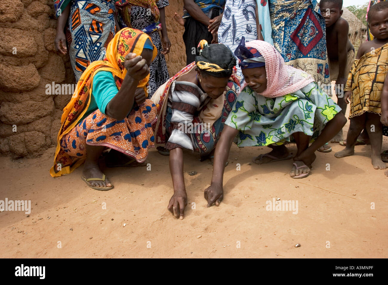 Trois femmes du village de jouer à un jeu de Dara avec graines de tournesol, le nord du Ghana Banque D'Images