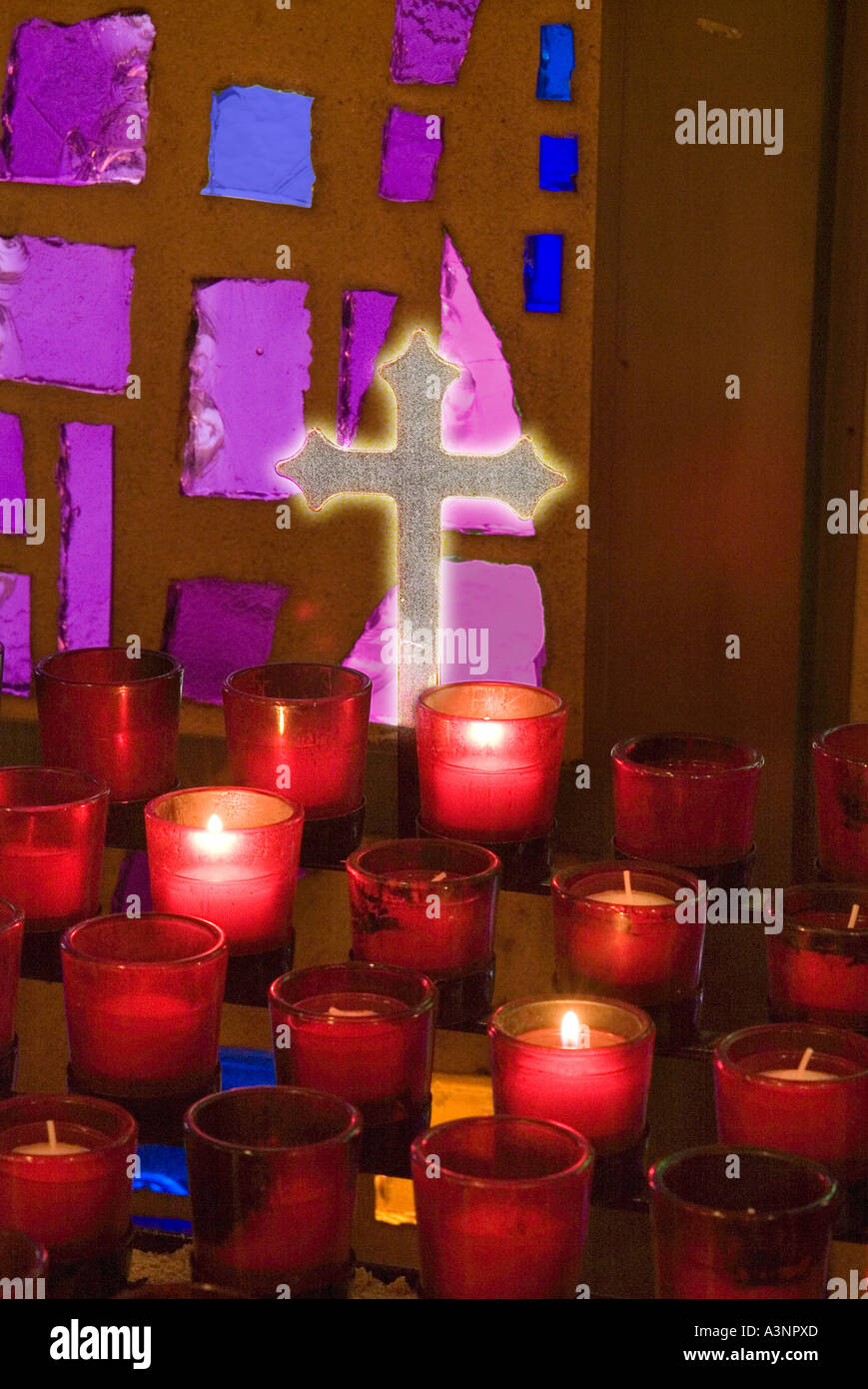 Croix dans l'église avec des bougies et des Vitraux Banque D'Images