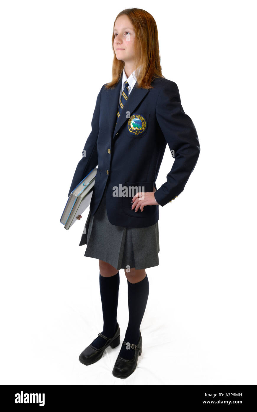 Jeune fille en uniforme de l'école privée avec des livres sur fond blanc Banque D'Images