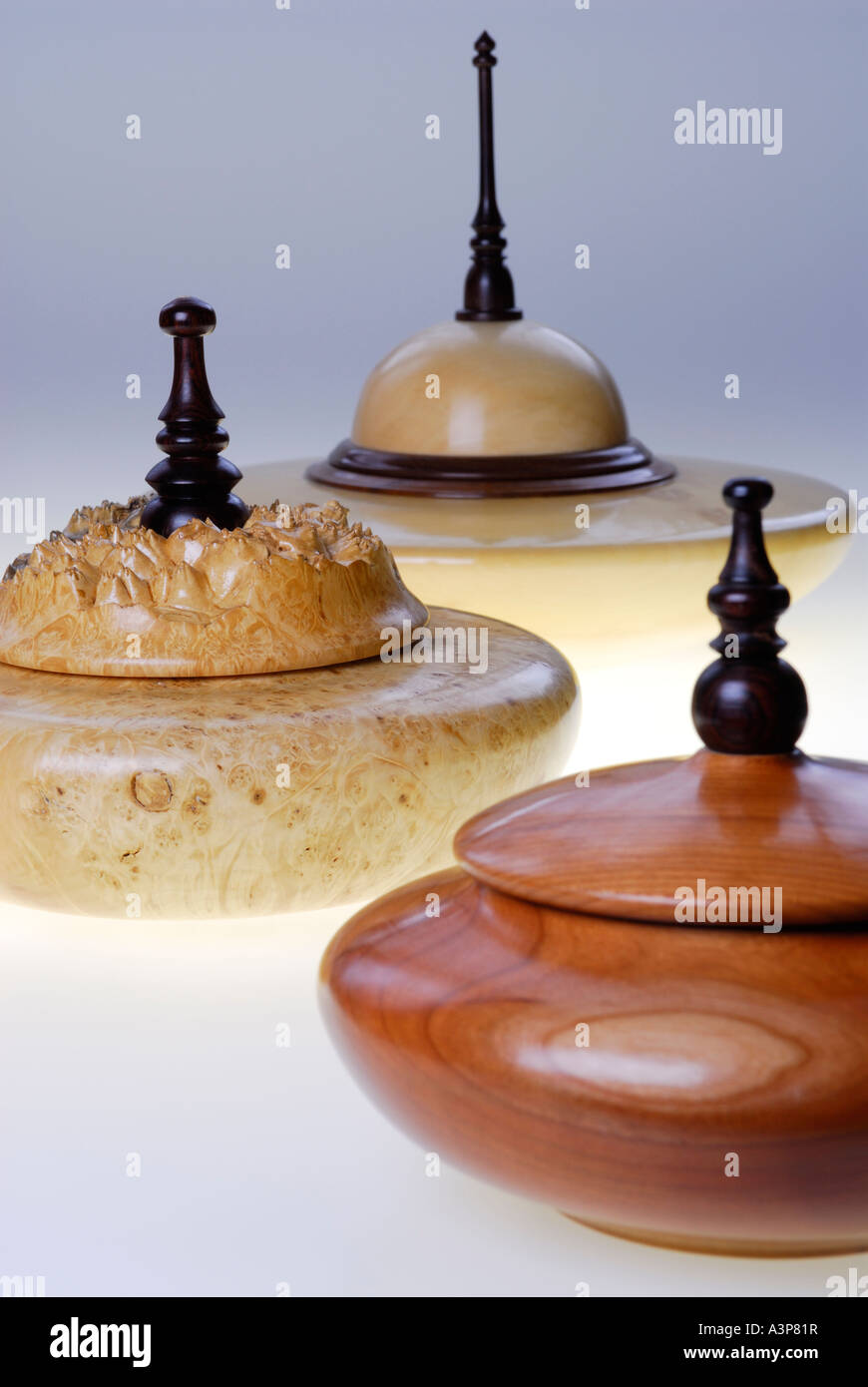 Trois bols en bois tourné à la main avec des poignées de porte en bois de rose sur fond bleu Banque D'Images