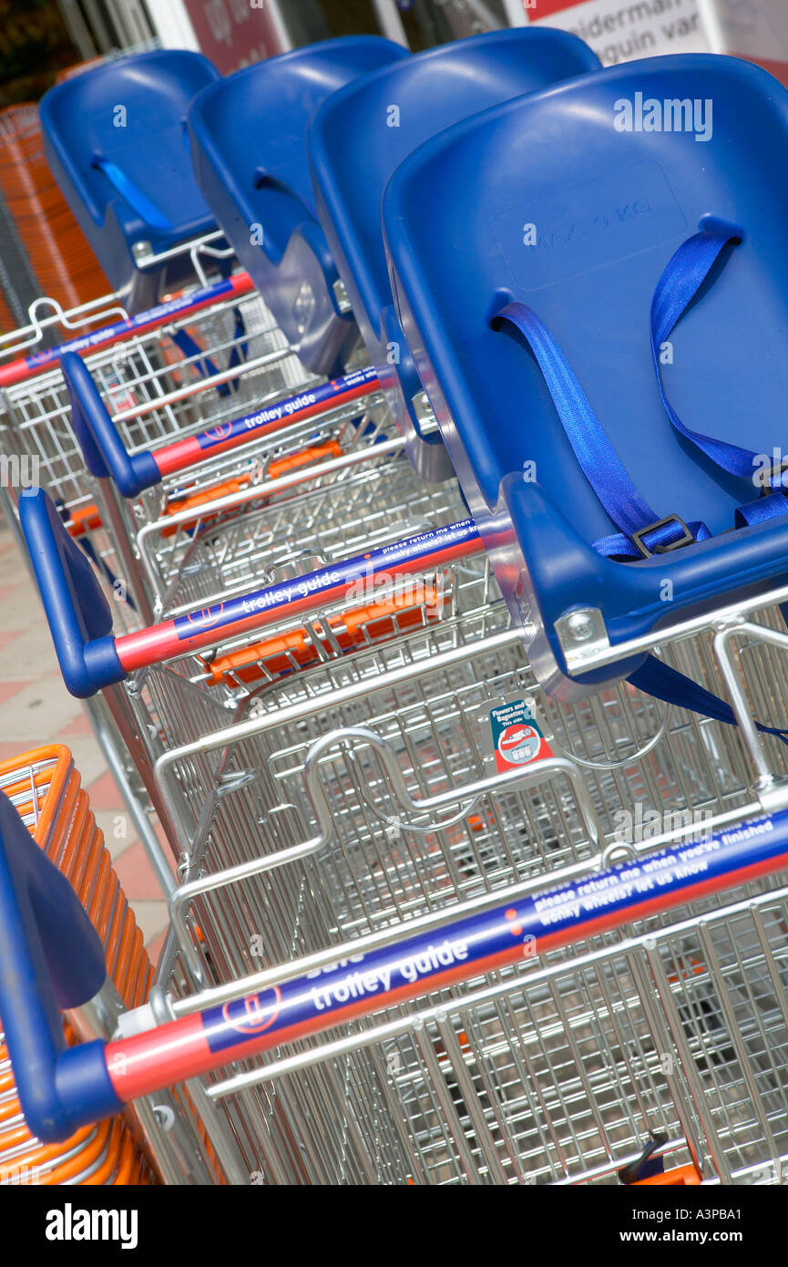 Chariots de supermarché stationné dans des rangées de sièges enfant Banque D'Images