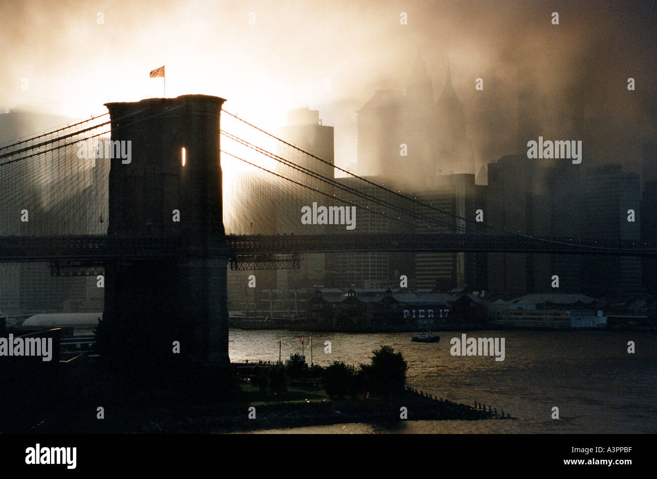 Coucher du soleil à travers la fumée du WTC attentats terroristes du 11 septembre 2001 encadre les pylônes du pont de Brooklyn Banque D'Images