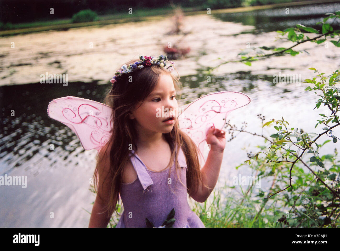 Jolie jeune fille jouant au bord d'un lac Banque D'Images