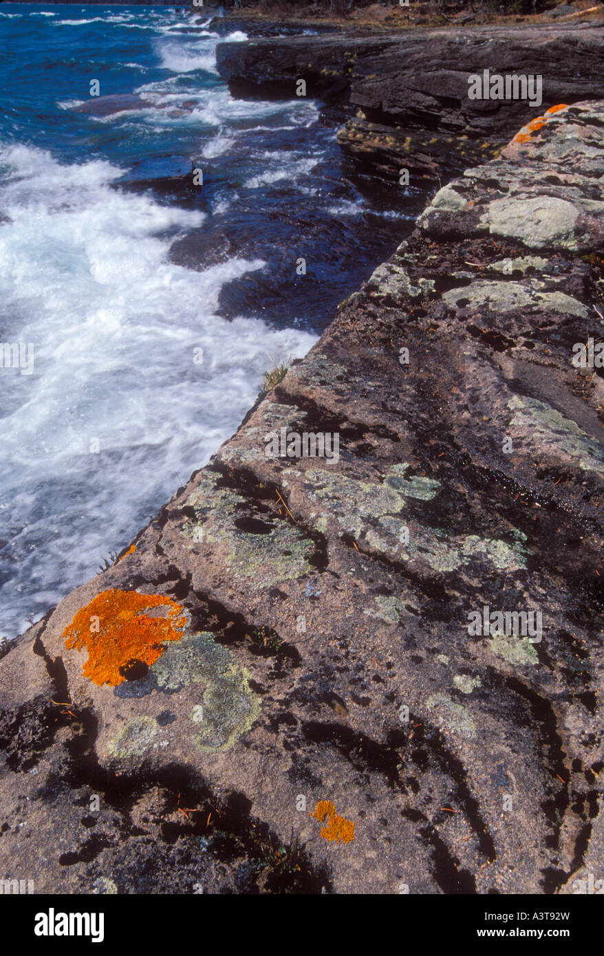 Les lichens aux couleurs vives parsèment le littoral accidenté de l'Abbaye près de la péninsule de L Anse Mich comme le lac Supérieur les vagues déferlent au printemps Banque D'Images