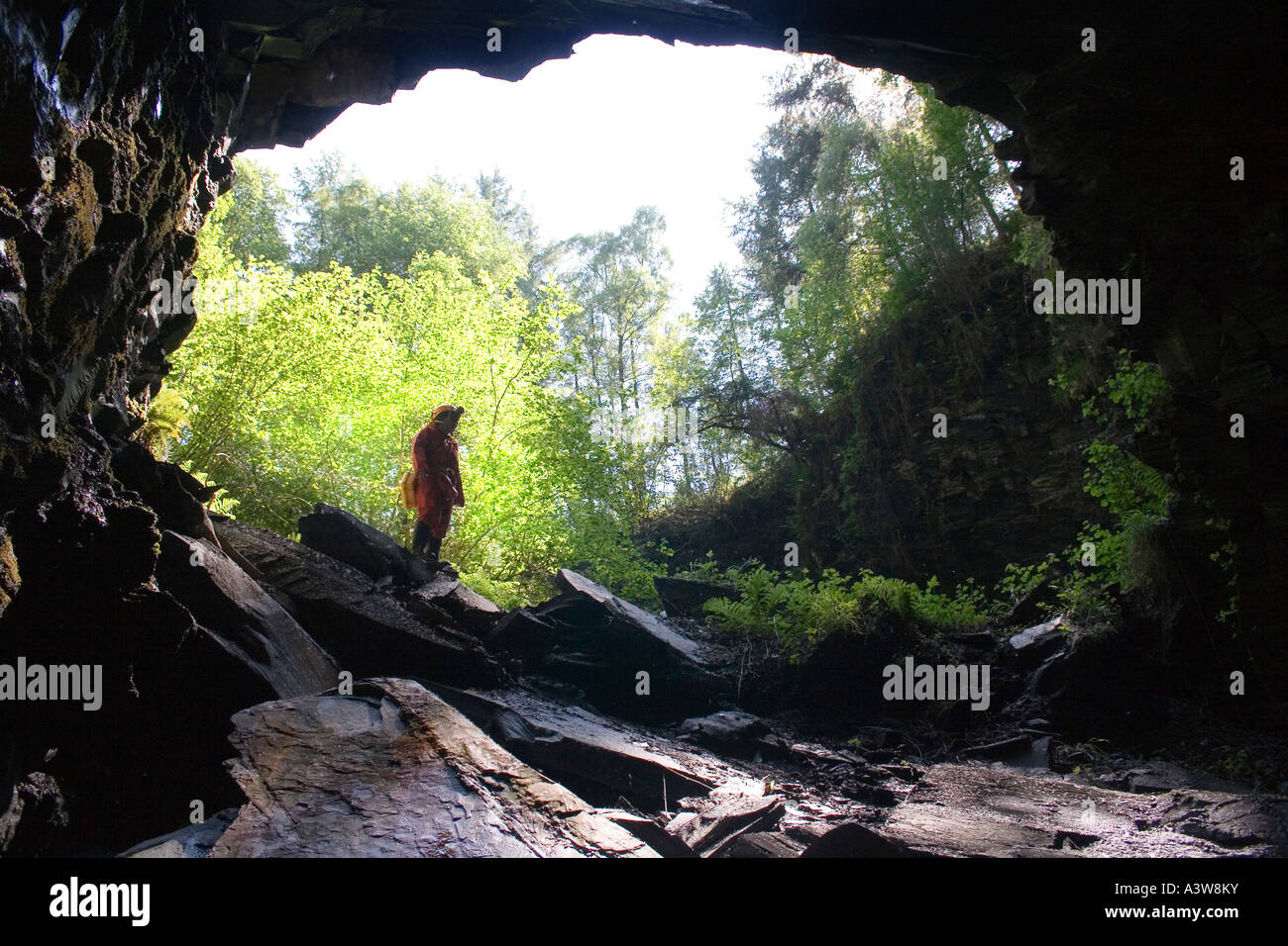 Femme debout dans l'entrée de la mine d'ardoise Cambrian abandonnés dans le Nord du Pays de Galles UK Banque D'Images