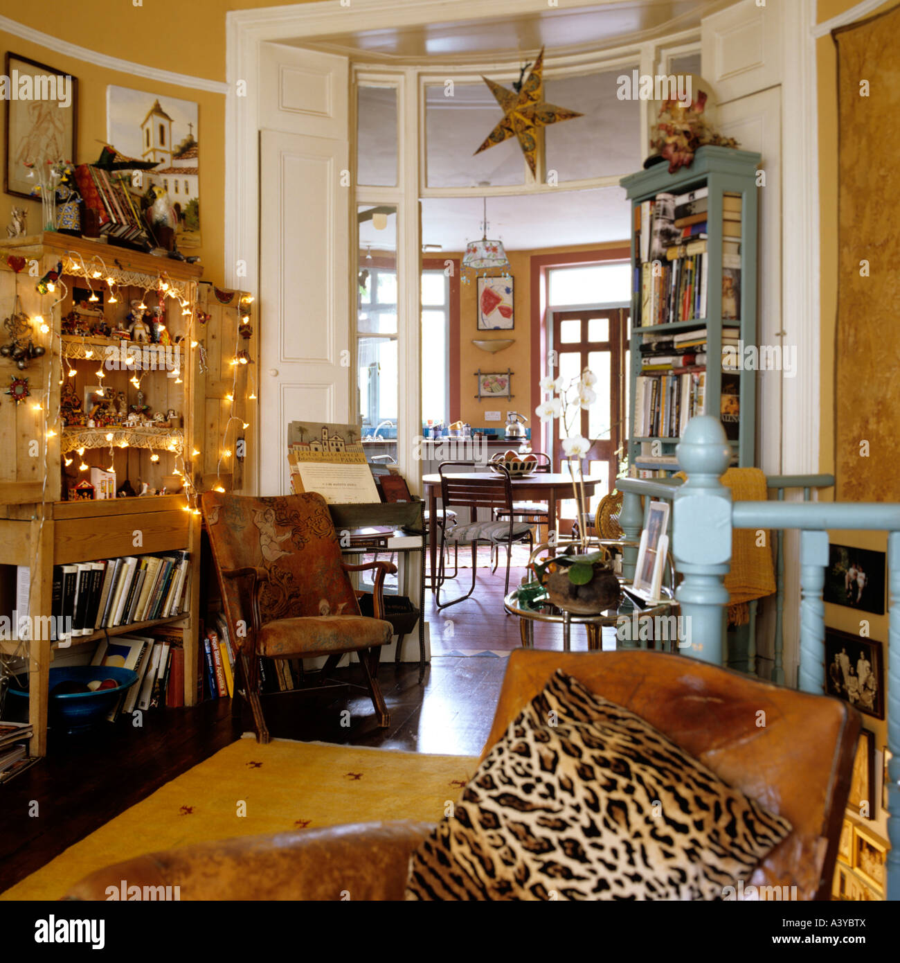 Quirky salon avec Leopard print coussin et voir à travers à la cuisine Banque D'Images