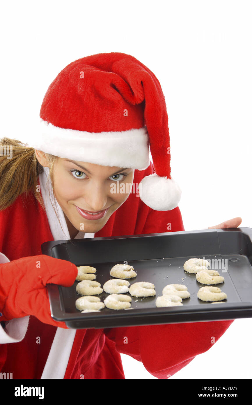 Jeune femme en costume père noël offrant des cookies sur le bac Banque D'Images
