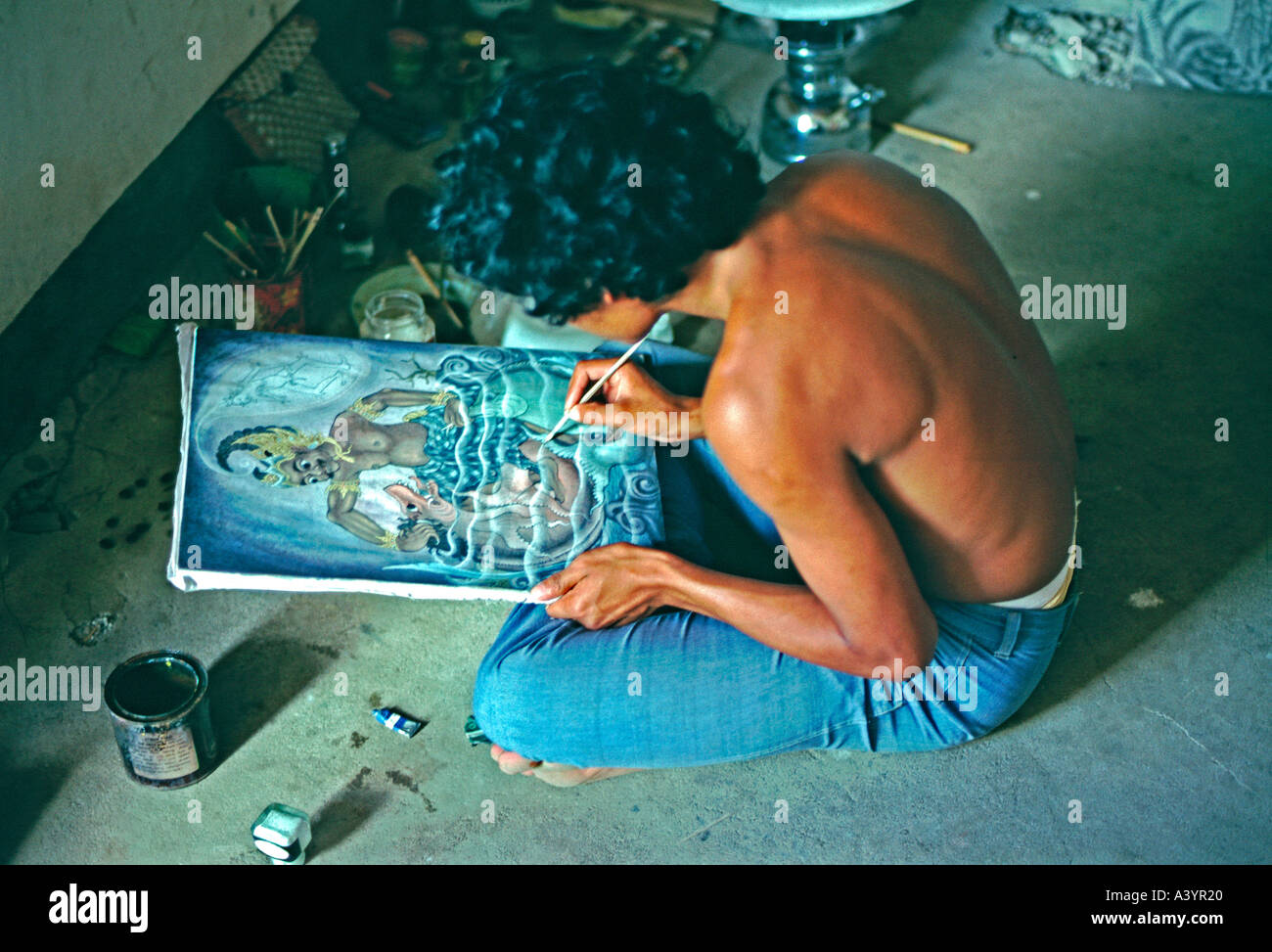 Un artiste balinais dans l'enclave d'œuvres d'artistes d'Ubud sur une peinture dans un style traditionnel Balinais Banque D'Images