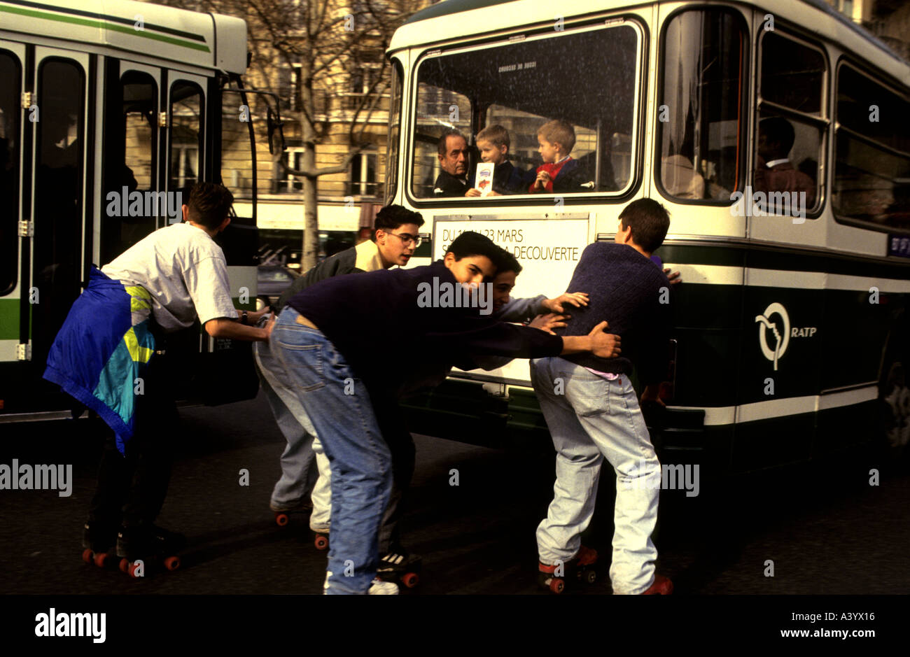 Les patineurs à roulettes un attelage gratuitement tout en maintenant l'arrière d'un autobus à Paris, France. Banque D'Images