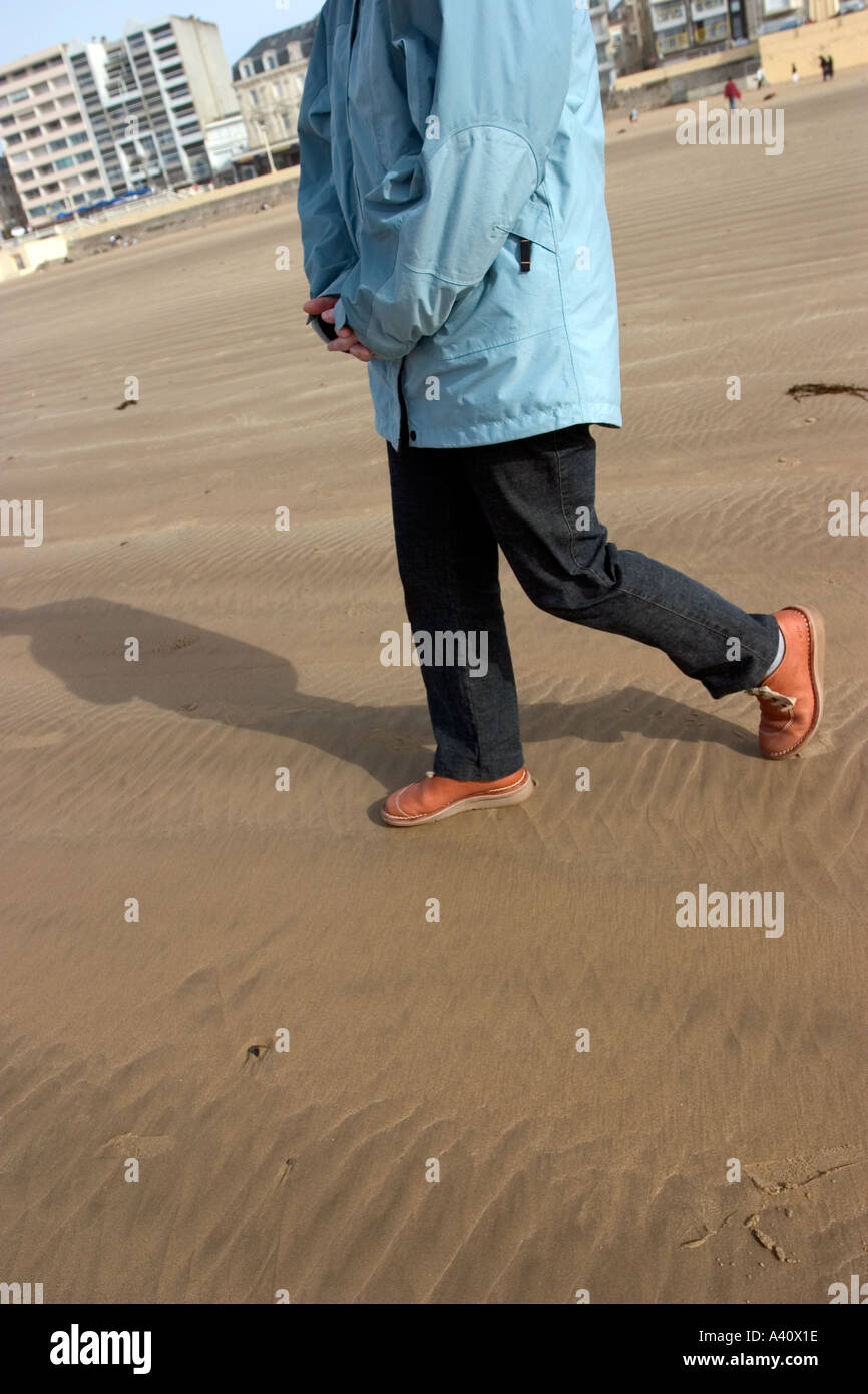 Jambes et Pieds de femme marche sur une plage d'hiver français Banque D'Images