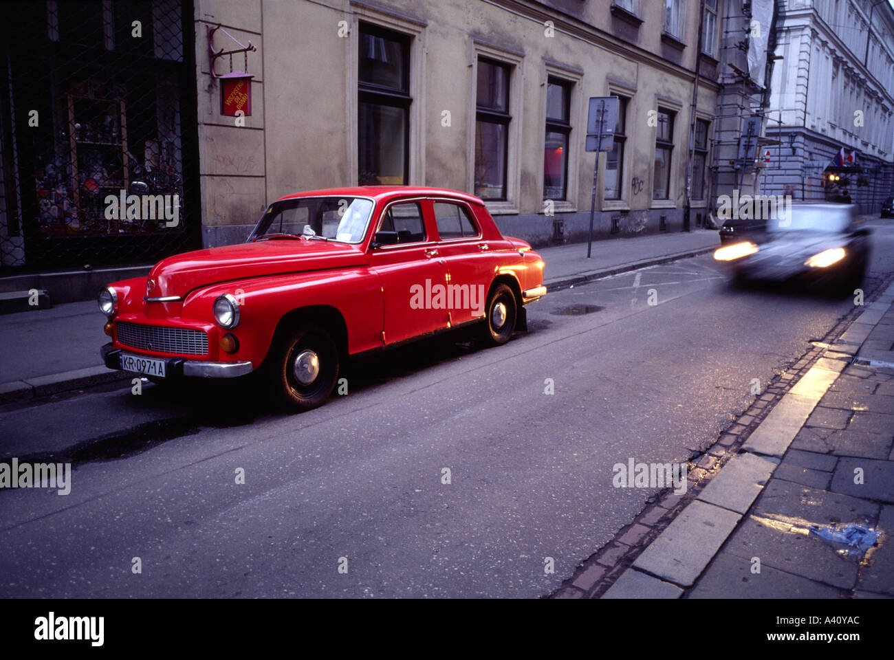Scène de rue avec une voiture rouge à Cracovie Pologne Banque D'Images