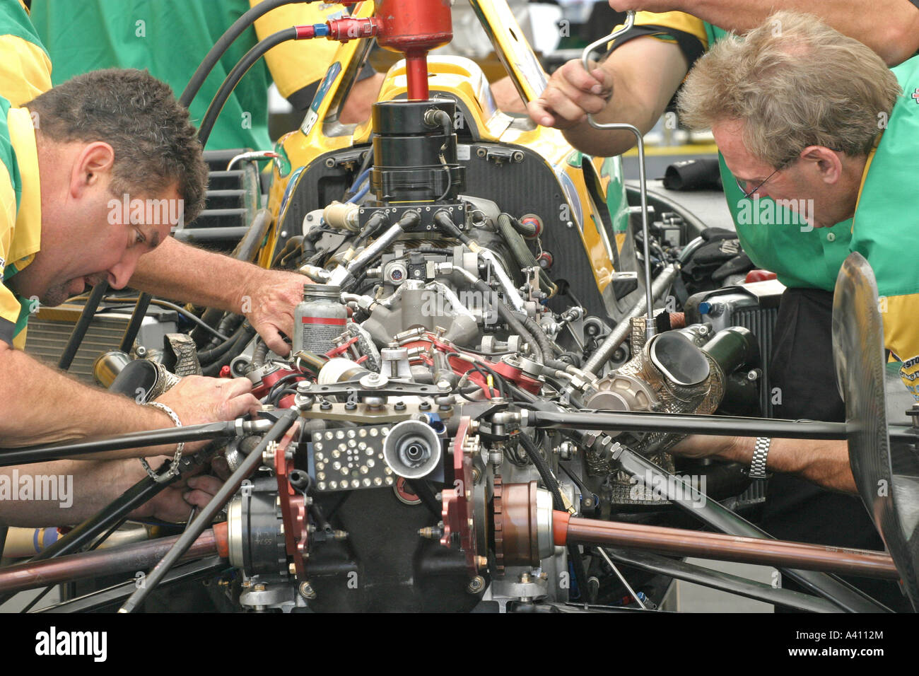 Équipe de mécaniciens travaillant sur le moteur de voiture de course Banque D'Images