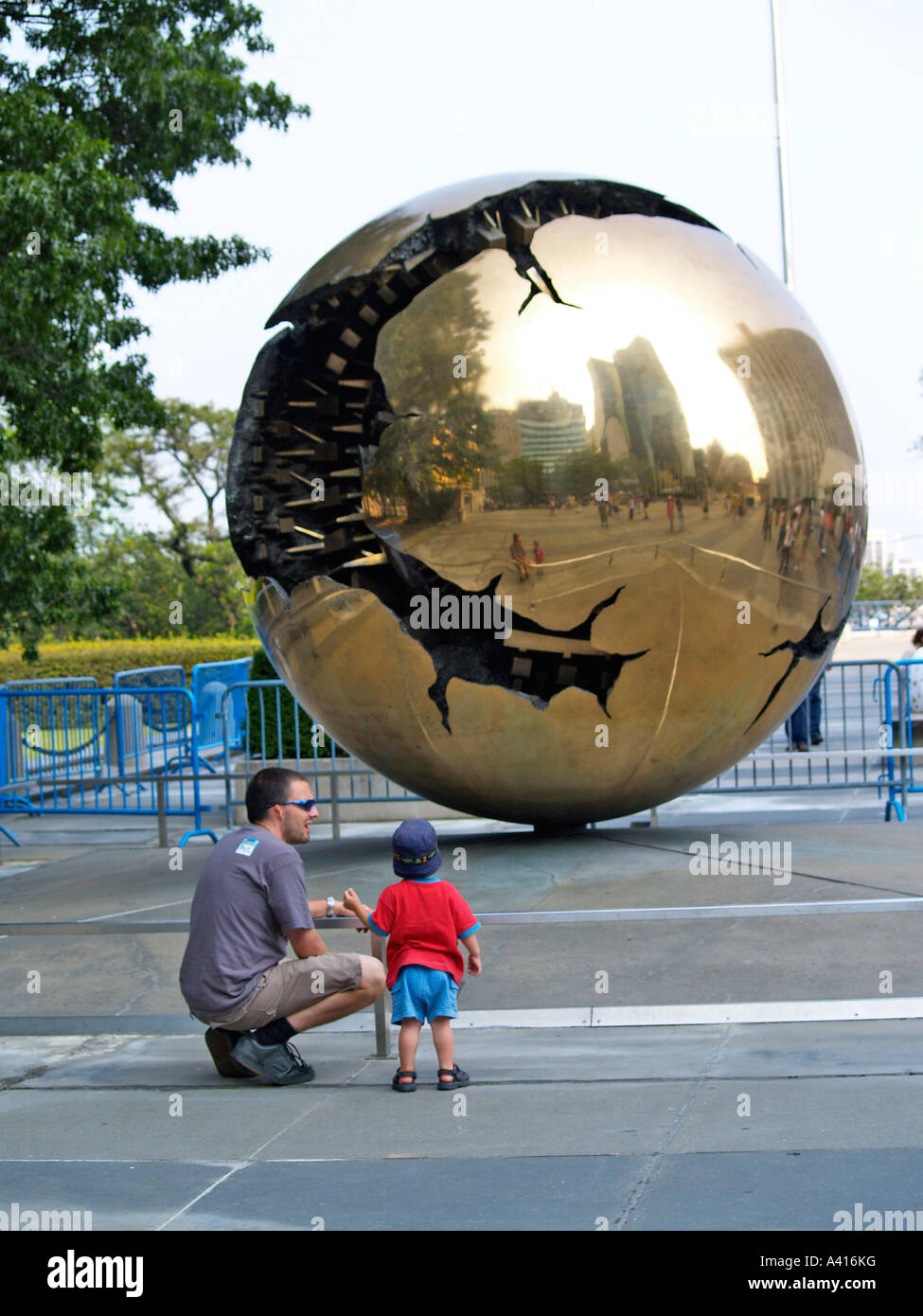 L'enfant et le parent bénéficiant au sein d'une sphère sphère par Arnaldo Pomodoro à l'Organisation des Nations Unies New York USA Voyages Banque D'Images