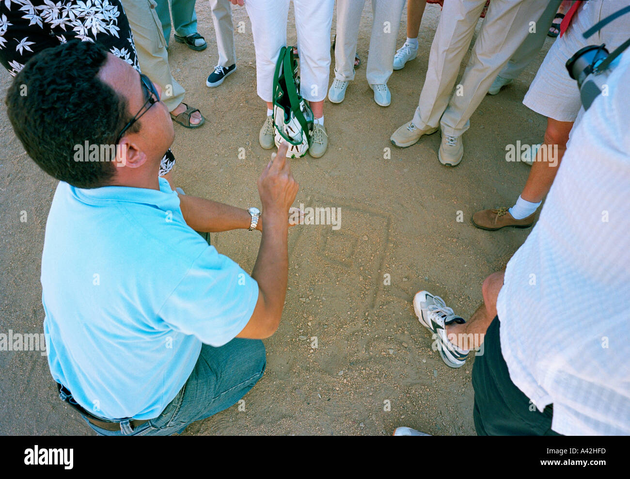 Un guide touristique illustre graphiquement l'architecture des temples dans la poussière au temple d'Horus à Edfou, sur le Nil Banque D'Images