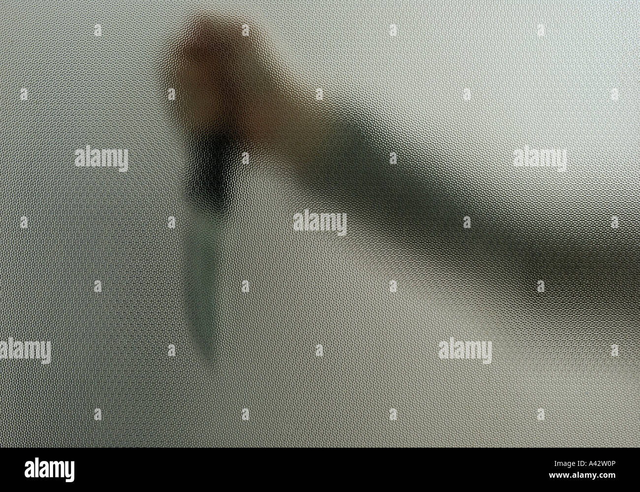 Le bras avec le couteau derrière un verre dépoli Banque D'Images