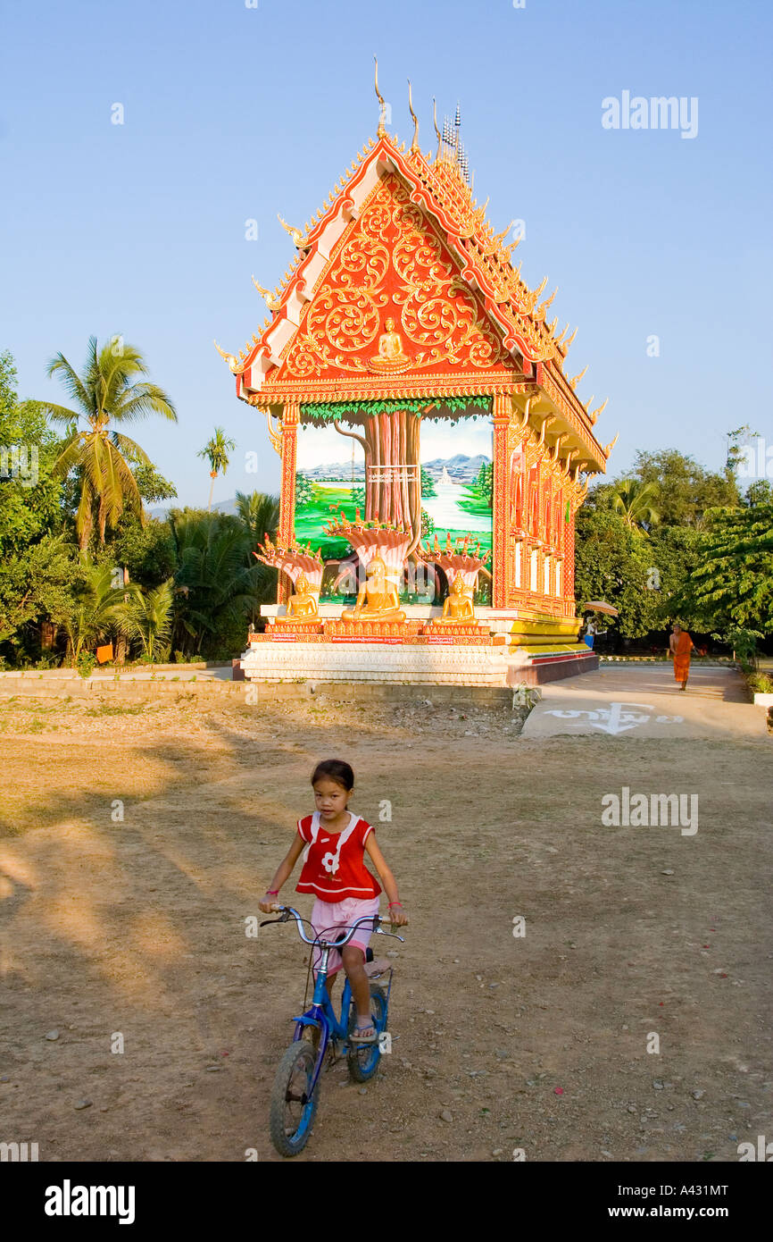 Petite fille sur un vélo au temple Wat Si Sau MangVang Vieng Laos Banque D'Images