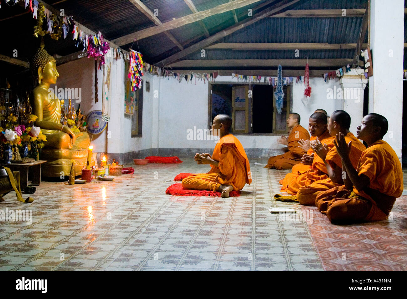 Les moines novices en prière Wat Thad que Vang Vieng Laos Banque D'Images