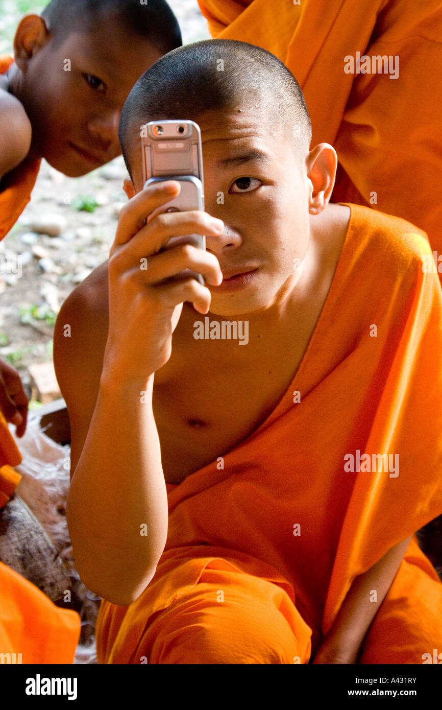 Monk essayant un appareil photo Téléphone Mobile Wat Thad que Vang Vieng Laos Banque D'Images