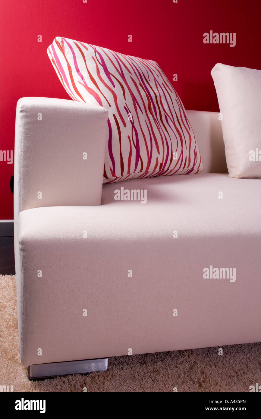 Canapé dormeuse moderne blanc contre un mur rouge Banque D'Images