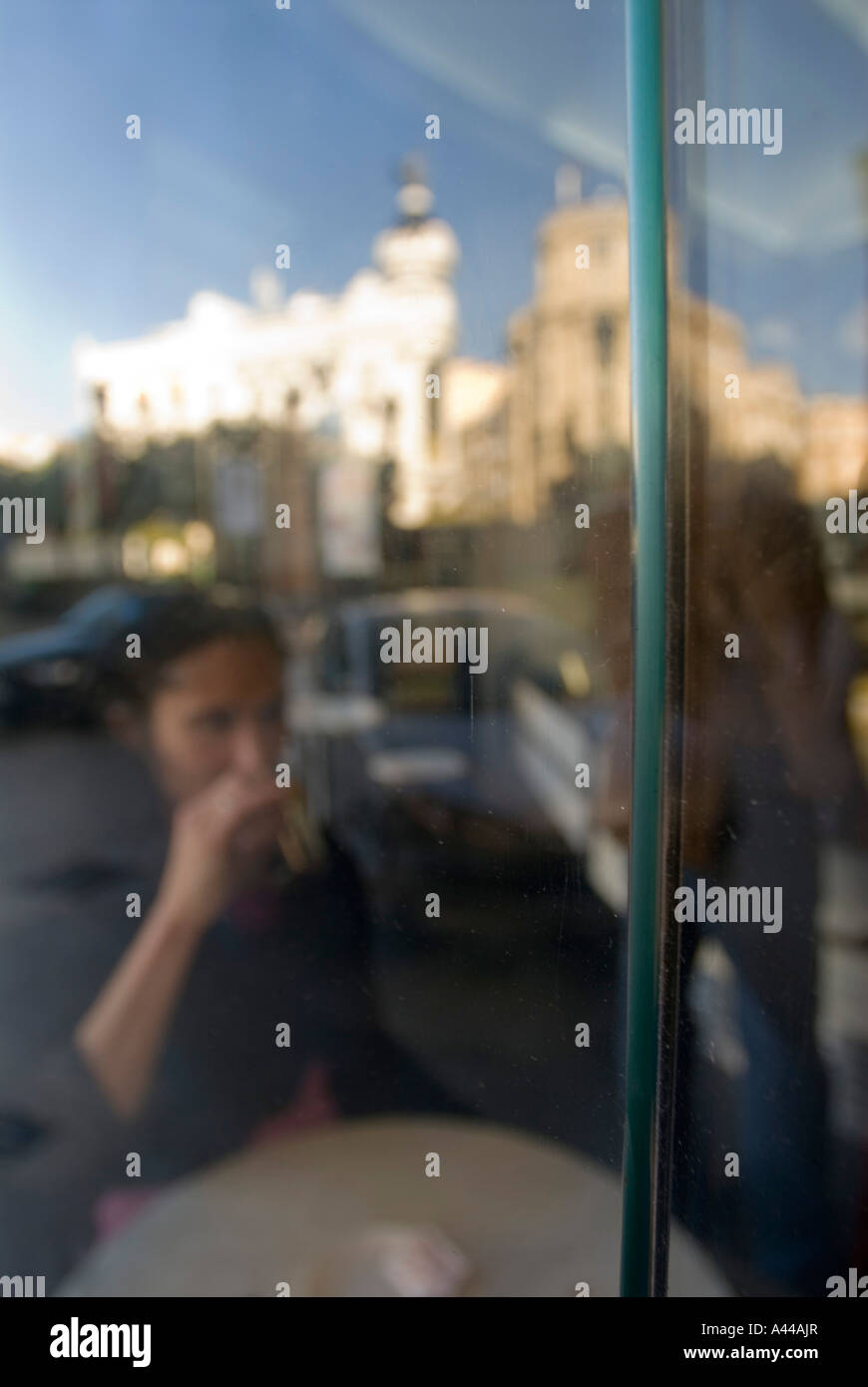 Femme de boire du café dans un café, en regardant par une fenêtre Banque D'Images