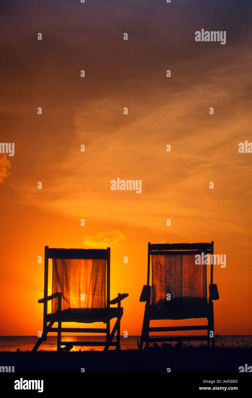 Deux chaises de plage dans le coucher du soleil Banque D'Images