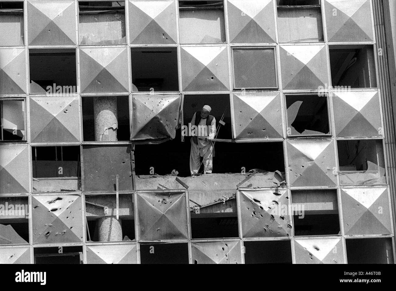 Un homme âgé inspecte les dommages causés à son bâtiment après l'attaque au cours de combats entre les seigneurs à Kaboul, l'Afghanist Banque D'Images