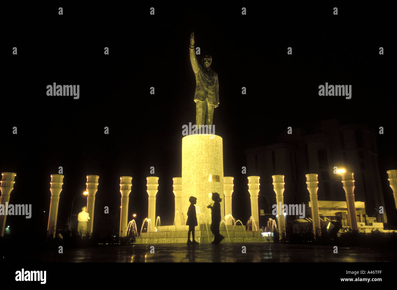 Deux enfants en dessous d'une statue de Saddam Hussein avec fontaines et lumières dans Bagdad Banque D'Images