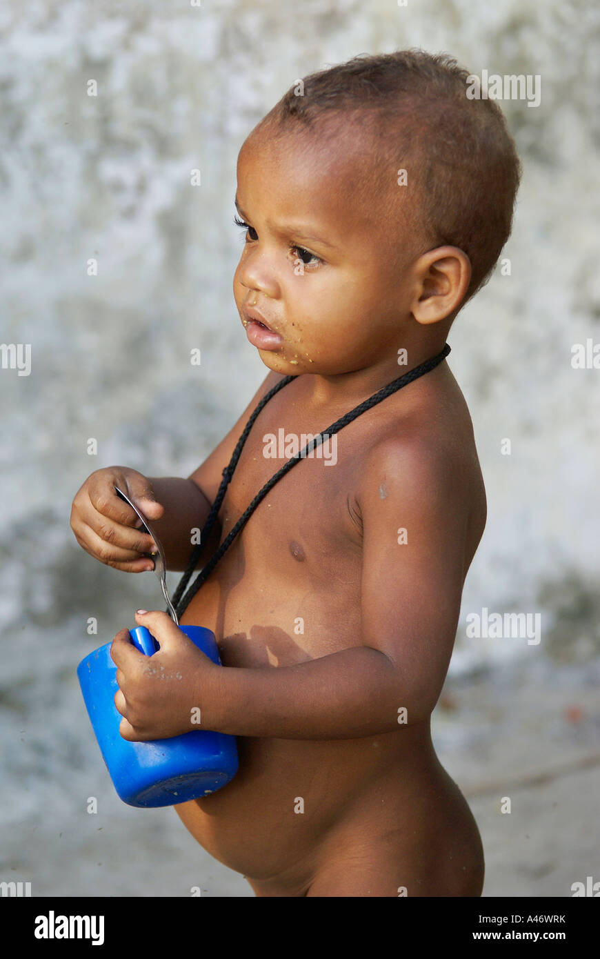 Pauvre garçon avec tasse en plastique et une cuillère, un Imbiribeira Favela, Recife, Brésil Banque D'Images