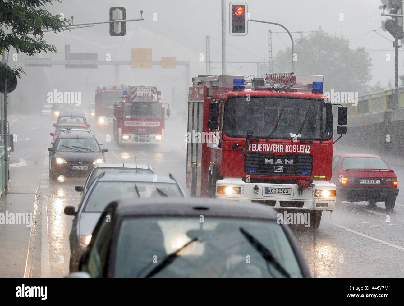 Une brigade de pompiers sur la voie d'une cession au cours de la pluie forte Banque D'Images