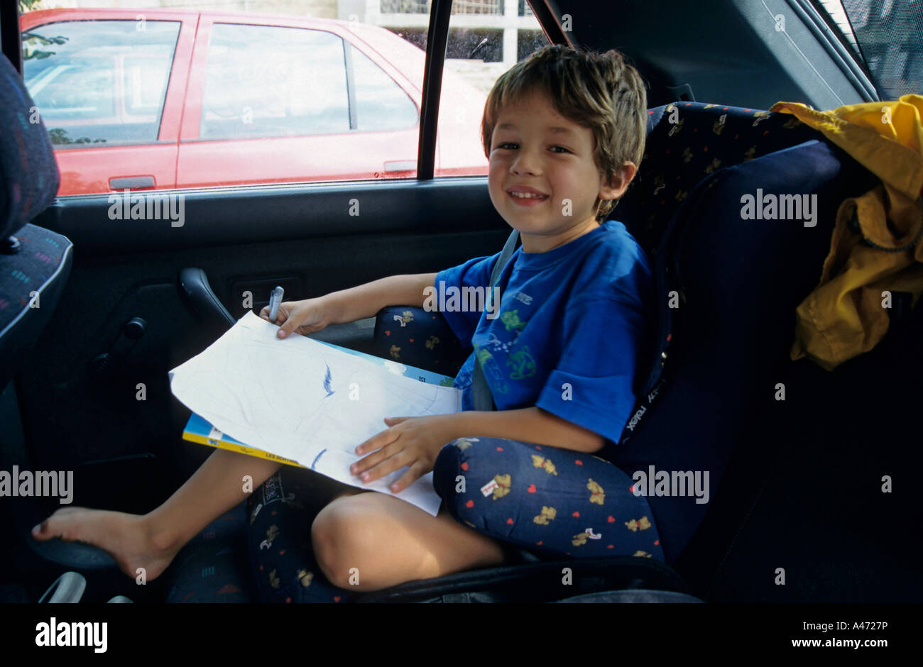 Jeune garçon dessin dans le siège arrière d'une voiture, de l'Espagne. Banque D'Images