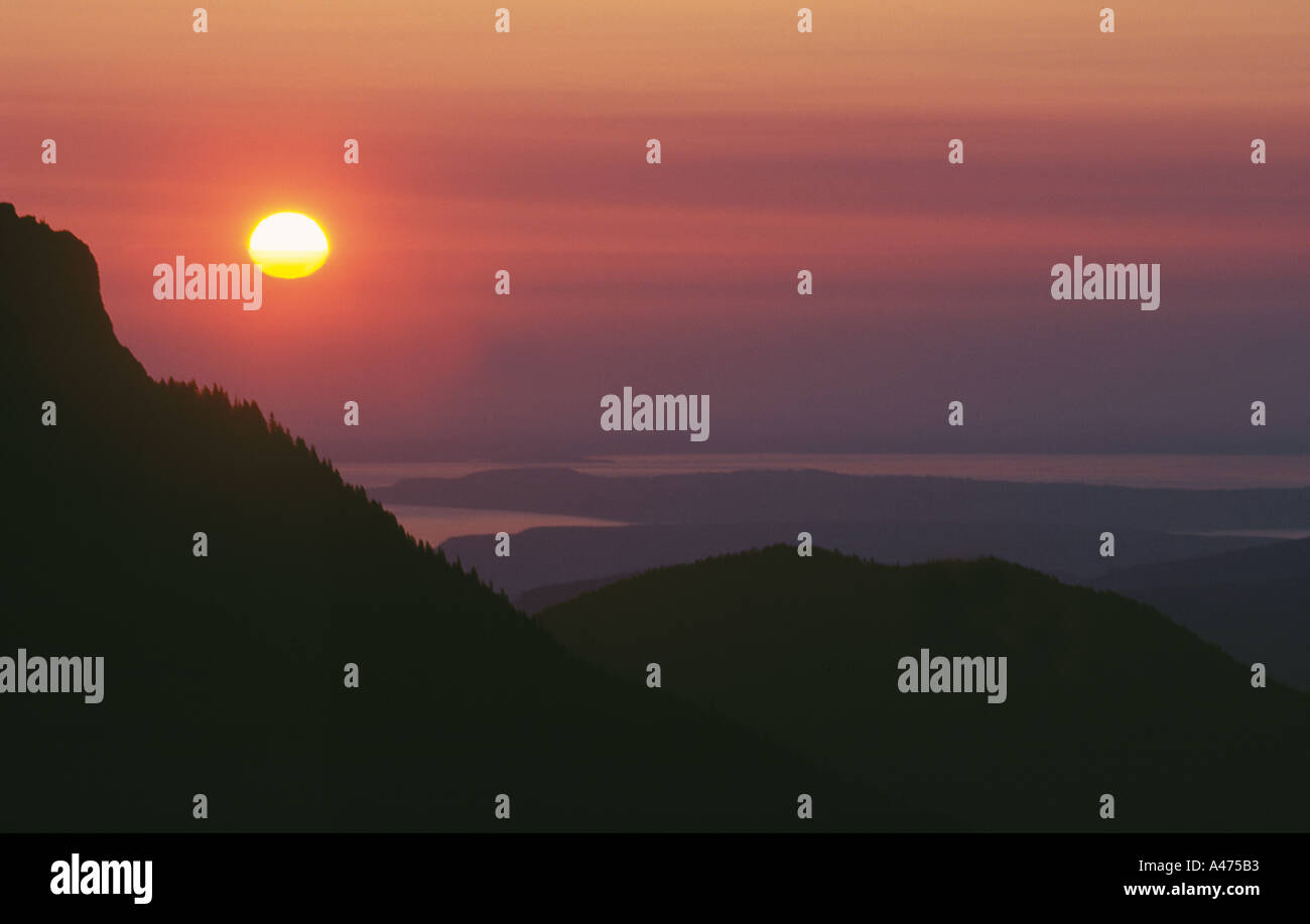 Un coucher de soleil rouge, tombe dans la vallée dominée par le Parc National Olympic dans l'État de Washington. Banque D'Images