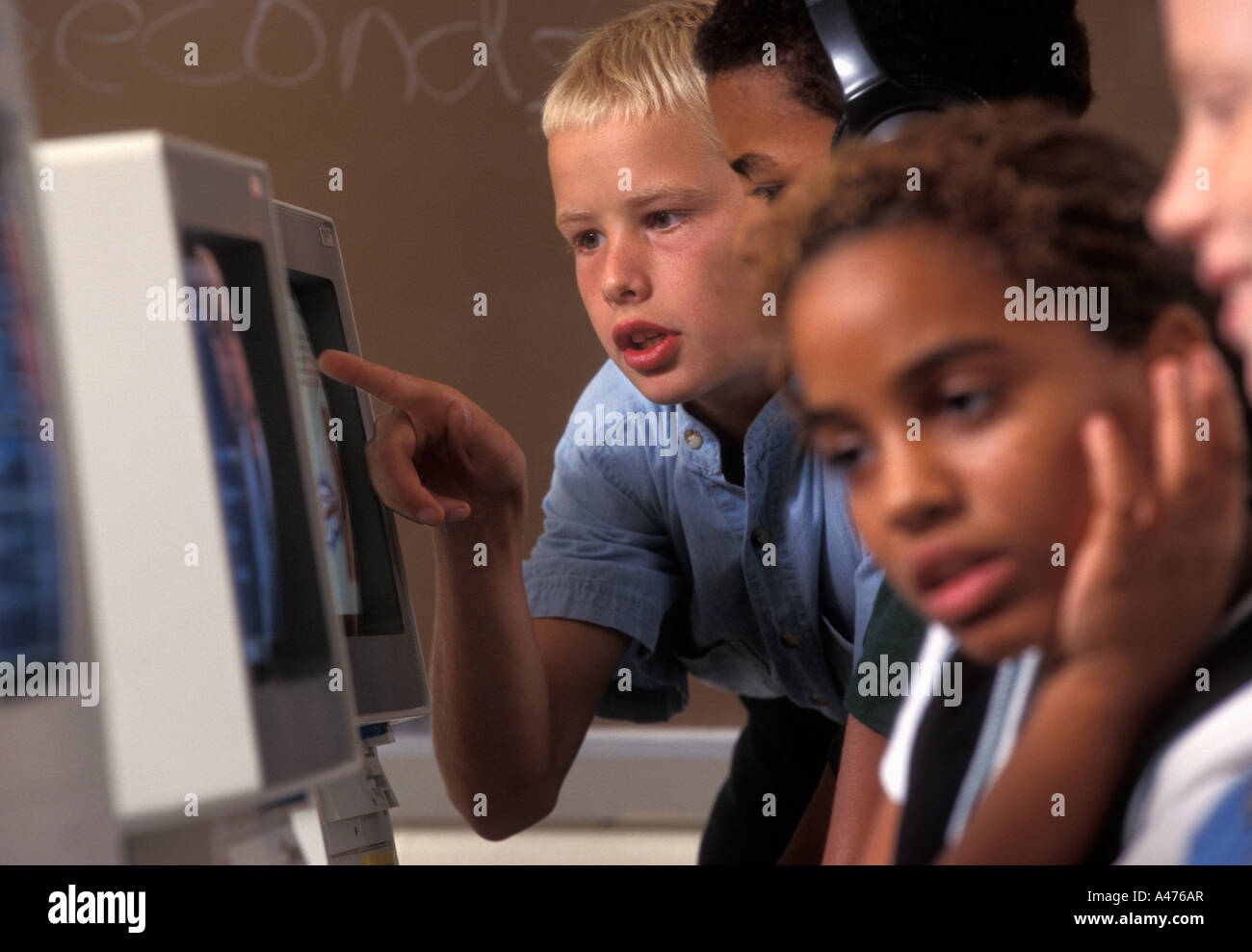 Les étudiants afro-américains et caucasiens dans l'école moyenne salle informatique Banque D'Images
